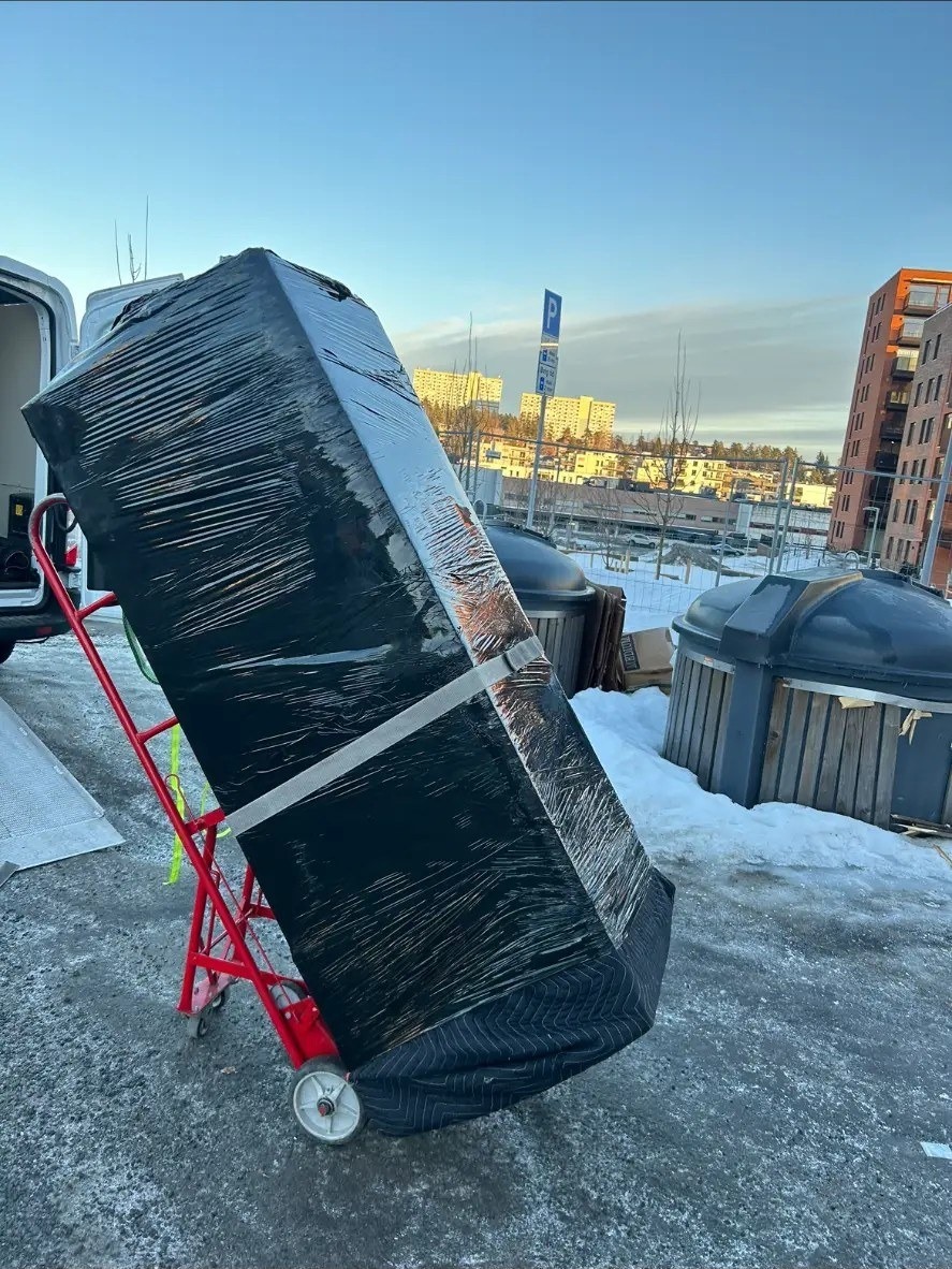 Innpakket piano sikret på tralle før transport